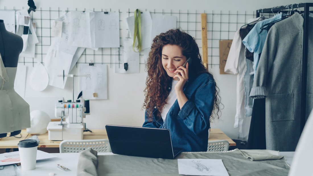 Dueña de un negocio atendiendo a sus clientes desde la notebook de su taller